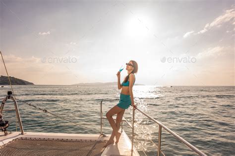 Asian Woman In Bikini Drinking Champagne While Having Party In Yacht