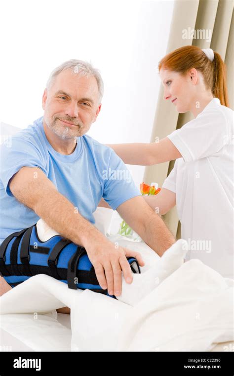 Hospital Female Nurse Take Care Of Patient With Broken Leg Stock