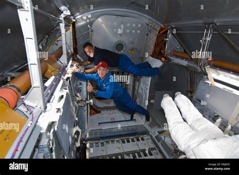 STS-128 Rick Sturckow and Jose Hernandez work in the Leonardo MPLM ...