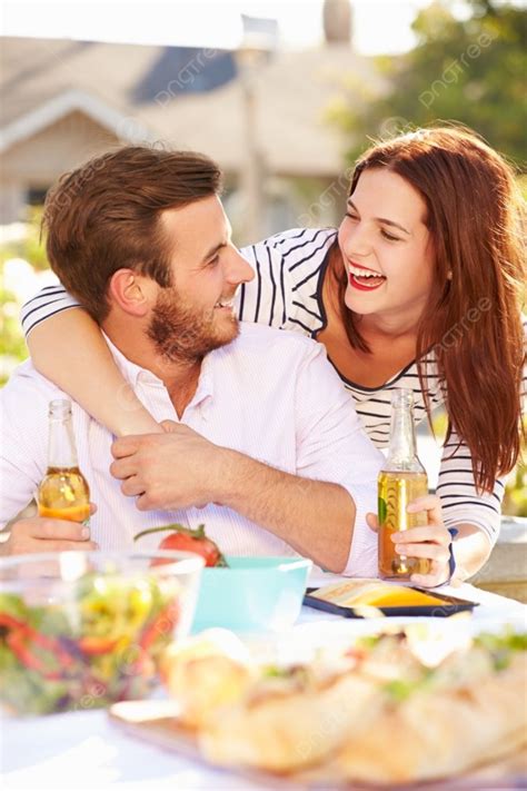 Romantic Couple Enjoying Outdoor Meal In Garden Background Person