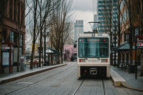 Modern tram riding on city railroadFree Stock Photo