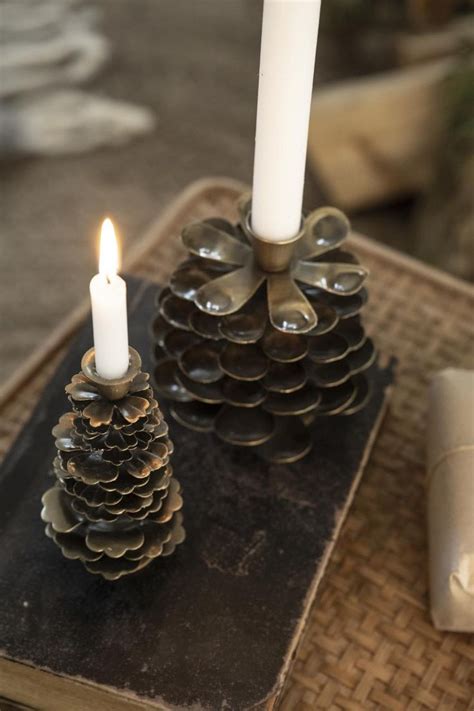 Two Pine Cone Candles Are Sitting On A Table