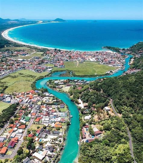 An Aerial View Of A River Running Through A Small Town Next To The