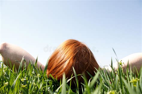 Redhead Que Pone En La Hierba Que Mira Para Arriba Imagen De Archivo