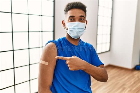 Young Hispanic Man With Beard Wearing Safety Mask Getting Vaccine