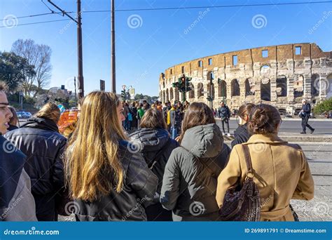 People Crossing The Road On The Crosswalk Next To The Coliseum In Rome