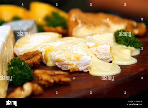 Cheese Plate With Melting Cheese Parsley And Wall Nuts Stock Photo Alamy