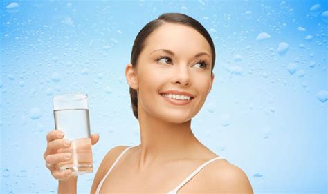 Mujer con un vaso de agua sobre fondo azul húmedo Foto Premium