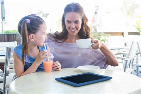 Premium Photo | Mother and daughter at cafe terrace