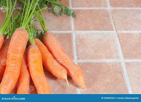 Bos Van Wortelen In De Keuken Op Een Tegelachtergrond Stock Foto