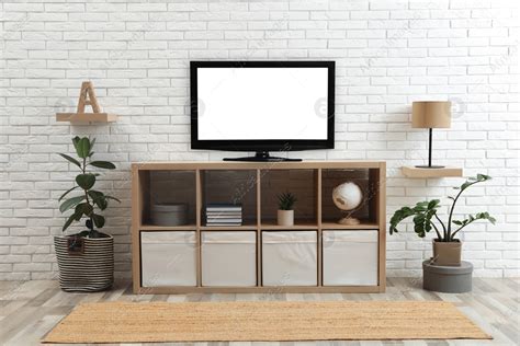 Modern Tv Set Near White Brick Wall In Living Room Stock Photo