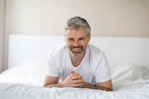 Premium Photo Portrait Of Happy Middle Aged Man Lying On Bed Smiling