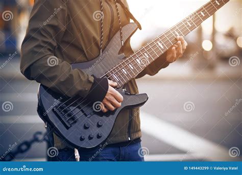 A Man Plays A Black Bass Guitar On The Street Stock Image Image Of Fretboard Artist 149443299