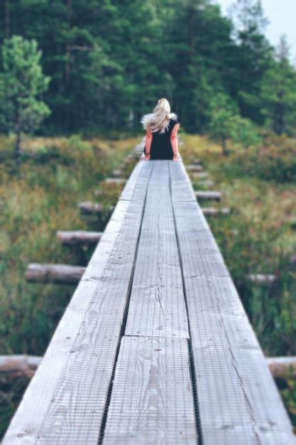 Vista Trasera De Un Hombre Caminando Por La Madera En El Bosque Foto