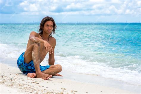 Premium Photo | The guy sitting on the beach