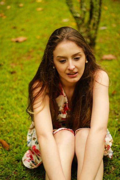 Premium Photo Young Woman Sitting On Grass