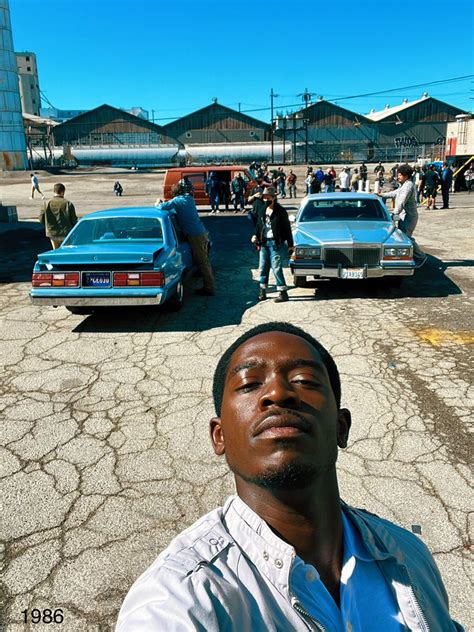 A Man Is Standing In Front Of Some Cars