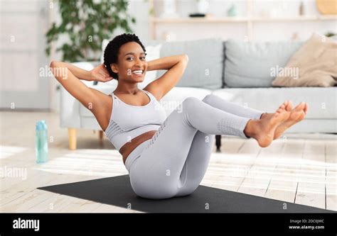 Young black woman with trained body doing abs exercise on yoga mat indoors Stock Photo - Alamy