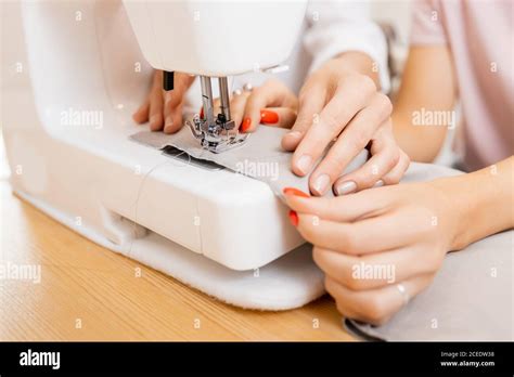 Close Up Sewing Machine Hands Of Tailor And Seamstress At Work