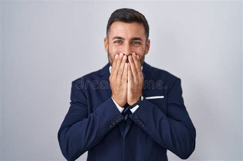 Handsome Hispanic Man Wearing Suit And Tie Laughing And Embarrassed