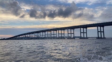 A Large Bridge Spanning Over The Ocean Under A Cloudy Sky