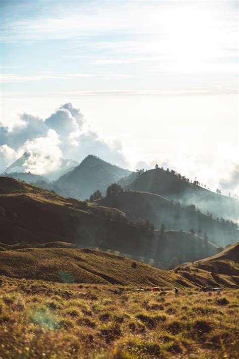 Hilly terrain on cloudy day at sunrise · Free Stock Photo