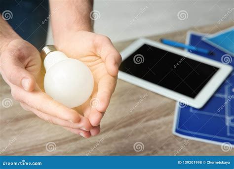 Man Holding Lamp Bulb Over Table Stock Photo Image Of Concept