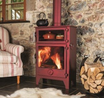 A Red Stove Sitting In The Middle Of A Living Room Next To A Fire Place