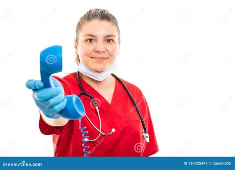 Young Medical Nurse Wearing Red Scrub Holding Blue Receiver Stock Photo