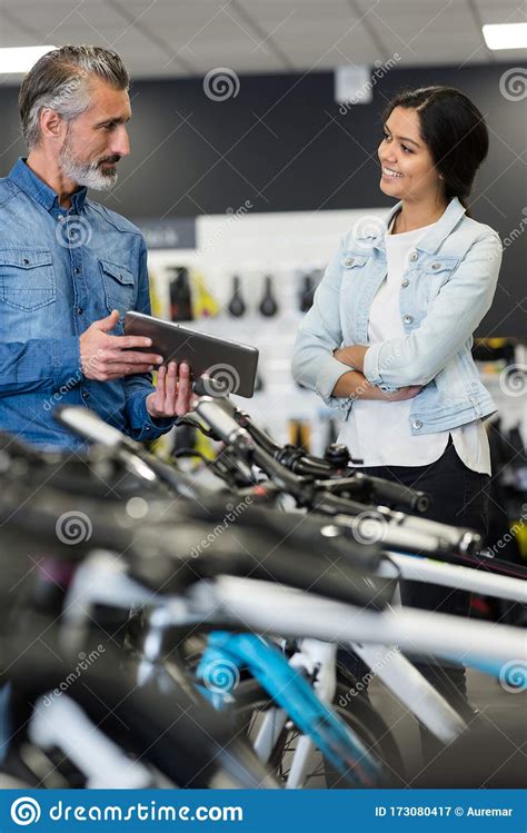 Vendedor Masculino En Una Tienda De Bicicletas Hablando Con Una Clienta