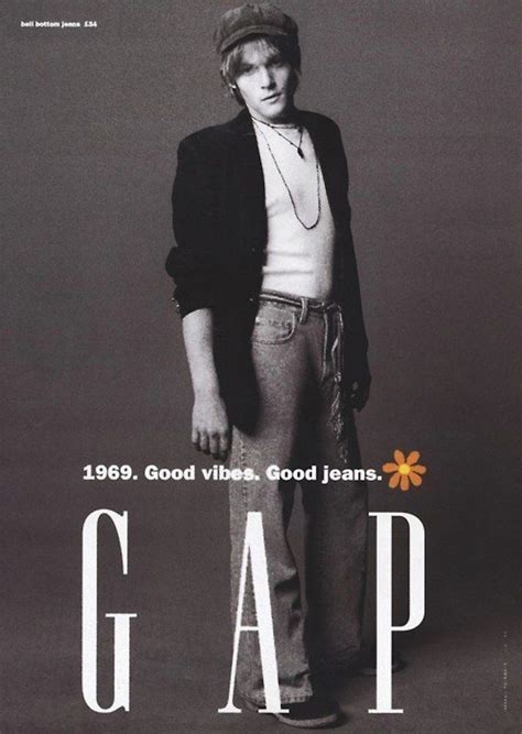 a man standing in front of a poster for gap