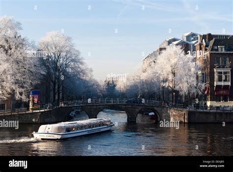 Tourist canal cruise boat turns from Amstel river onto Herengracht ...