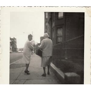 Two Women One Holding An Infant Walk Away From The Camera Digital