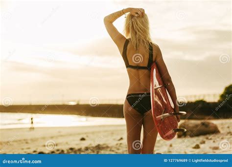 Back View Of Slim Female Surfer With Surfboard On Beach Stock Image