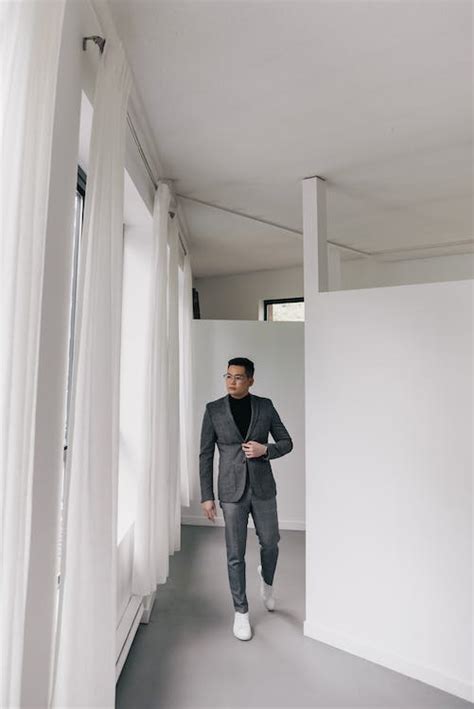 Man Wearing Suit Walking in Hallway · Free Stock Photo