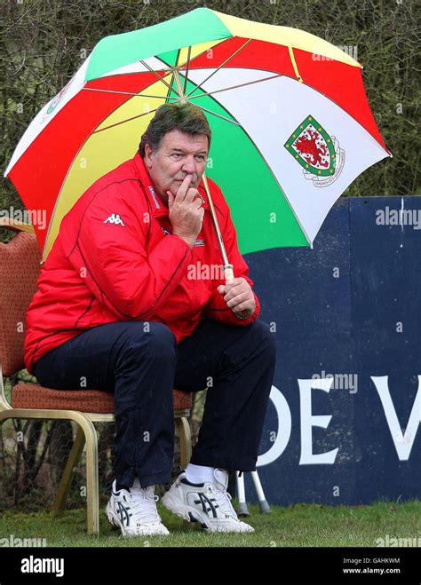 Wales manager John Toshack shelters from the rain during a training ...