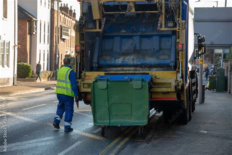 bin lorry or waster truck collects refuse from a green dumpster with ...