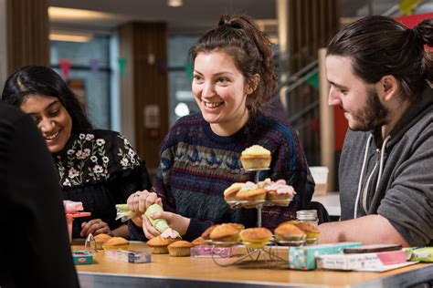 Three Students Enjoying Making Cakes Together