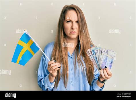 Jeune femme blonde portant le drapeau suédois et les billets de krone