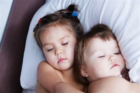 Deux Petites Filles Mignonnes Jouant Ensemble Sur Le Lit Image Stock