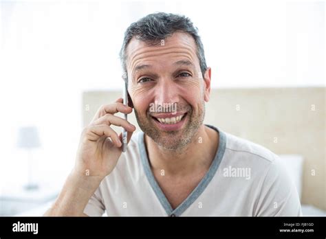 Man Talking On Smartphone In Bedroom Stock Photo Alamy