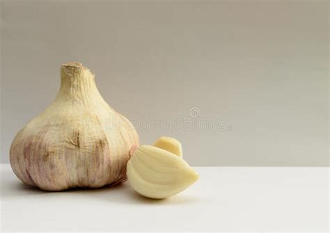 Cabeza De Ajo Fresco Al Lado De Dos Tejidos De Ajo Pelado Sobre Fondo