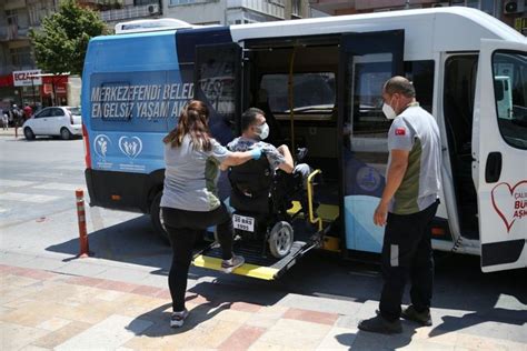 Two People Loading Luggage Onto A Bus On The Street With Another Person