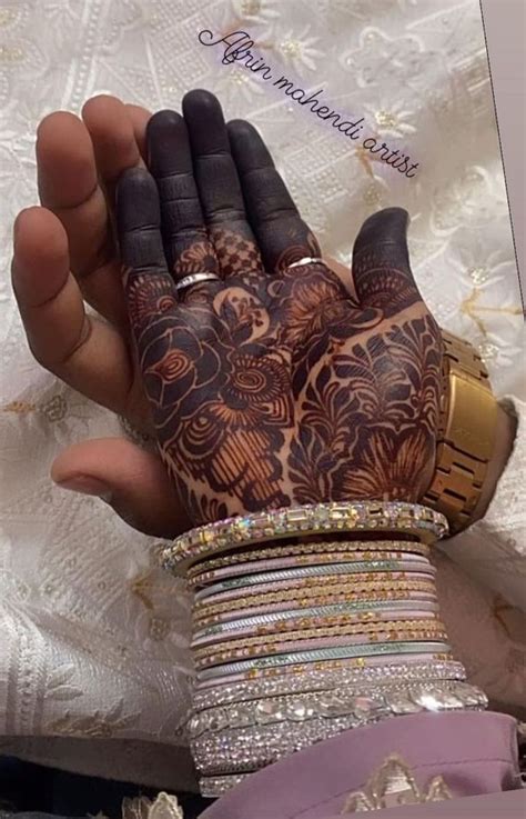 A Woman S Hands With Henna Tattoos And Bracelets On Top Of Them