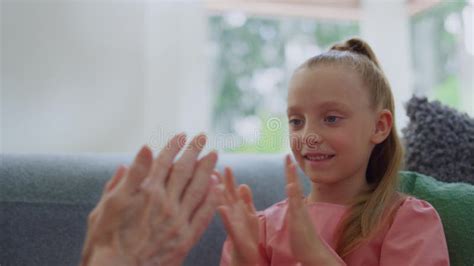 Portrait Of Pretty Girl Playing With Grandmother Hands In Living Room