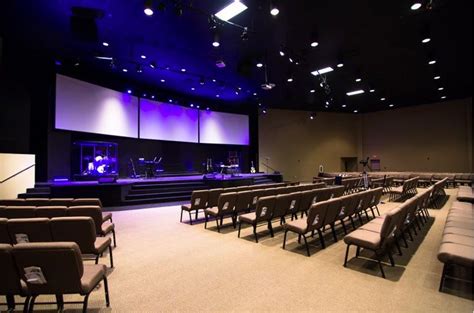 An Empty Auditorium With Rows Of Seats And Stage Lights On The Ceiling