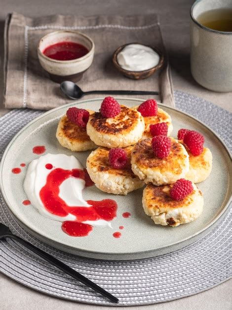 Premium Photo Cheesecakes Or Syrniki On A Round Plate With Raspberry