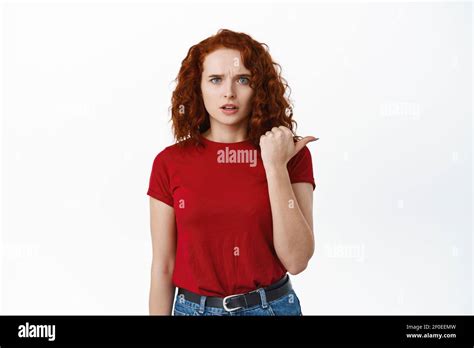 Confused And Upset Redhead Woman Pointing Finger Right Side Being Sad Frowning Face And