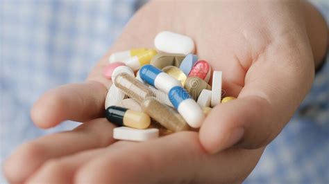 Handful Of Tablets And Capsules Of Various Shapes And Colors Lie In