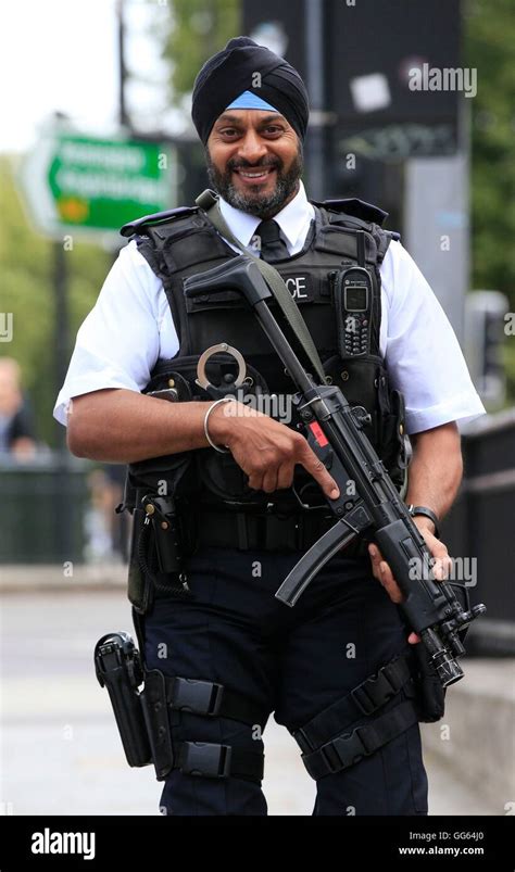 An armed Sikh police officer patrols as part of a security operation near the junction of ...